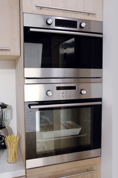 Architectural detail of chic modern kitchen with oven in the foreground 