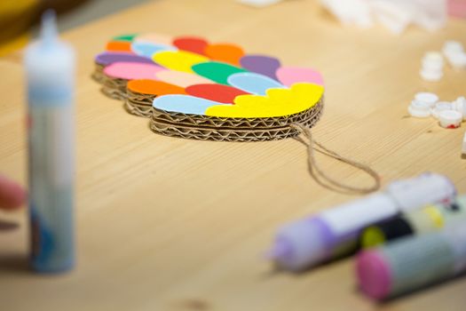 Colorful toys made of cardboard on a wooden table. Creative background