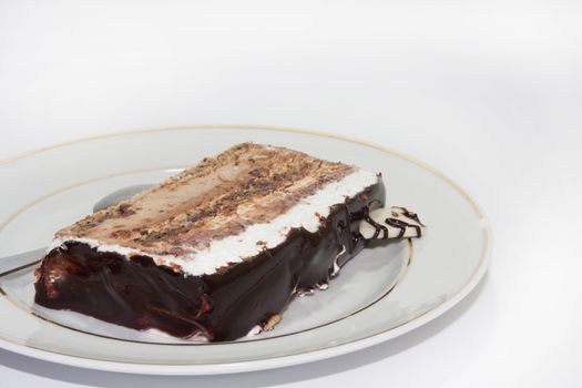 Piece chocolate cake on the white plate and white background.