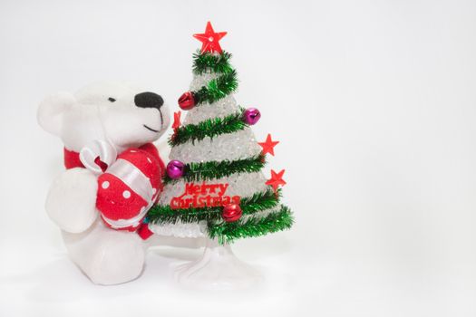 White teddy bear with christmas tree on the white background.