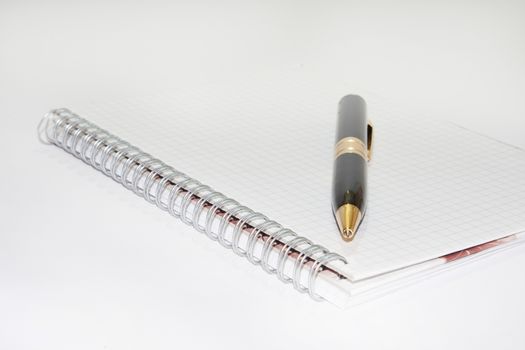 Black pen on the white paper notebook on the white background.