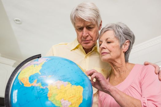 Senior couple choosing a travel destination at home in the kitchen