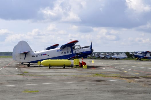 The green An-2 plane on a runway