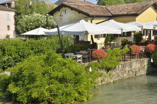 Restaurant next to the river Mincio in Borguetto, a ancient village  in the municipality of Valeggio, in the province of Verona; Italy.