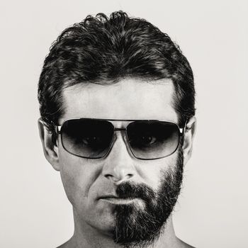 split personality - black and white portrait of man with half shaved face and sun glasses