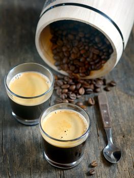 Hot espresso cup with coffee beans on wooden background