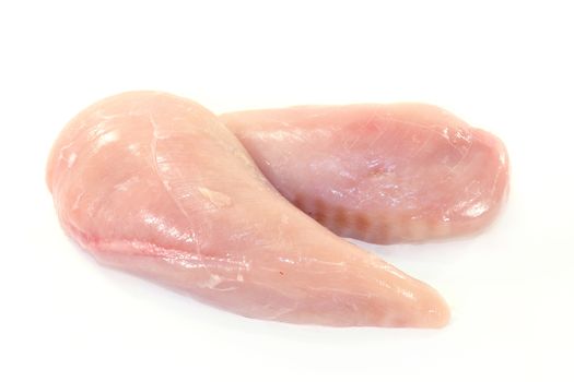 raw chicken breast fillets in front of white background