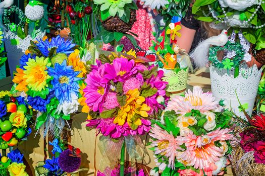 Bright and colorful decorative artificial flowers, figures of birds, animals and other Souvenirs are sold at the fair.