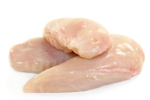 raw chicken breast fillets in front of white background