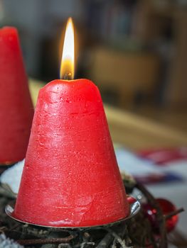 Detail shot of advent wreath burning red candle