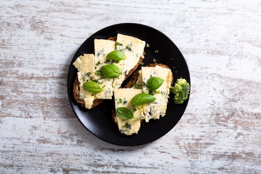 European style sandwiches with Roquefort cheese and Basil leaves on dark bread.
