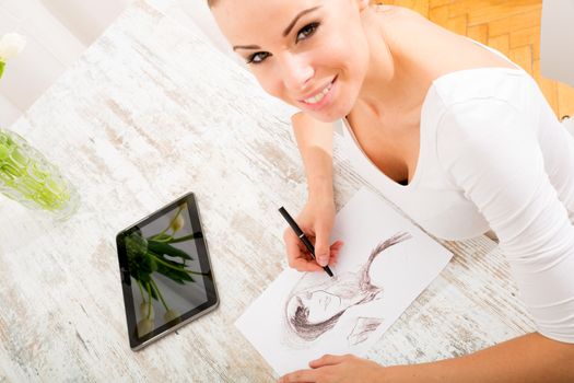 A young fashion designer working with a tablet pc.
