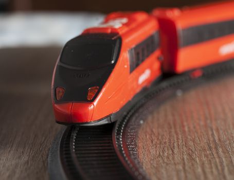 Red toy train running in strict close up