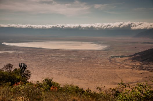 Clouds on the rim of the ngorongoro crater as viewed from the other side of the rim, with the lake clearly visible.