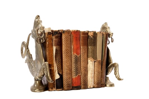 Eight old neglected and torn books between two book stands made of copper and resembling horses, photographed on an isolated white background.