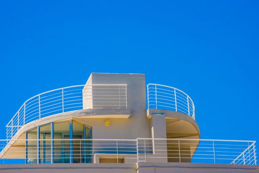 Balcony on top of an art deco apartment building with a view of the ocean.