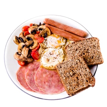 A plate full of food for breakfast, including two eggs, toast, ham and suasage.