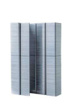 A tower of several lines of staples placed one next to the other to create the look of a high rise building in abstract. Photographed on a white background.