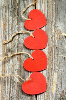 Four Red Hearts with Ropes In a Row on Rustic Wooden background