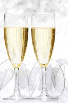 Two glasses of champagne with bow on silver background