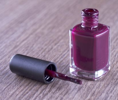 Red nails polish over a wooden background