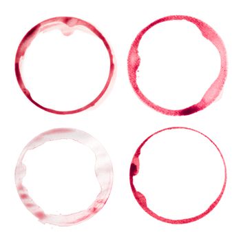 Photo of four different red wine stains from wine glasses on white background.