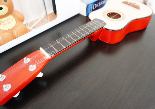 In front of the window has one guitar placed on the shelves of home decor.                              