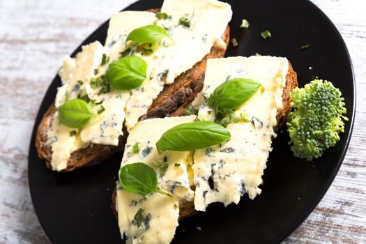 European style sandwiches with Roquefort cheese and Basil leaves on dark bread.
