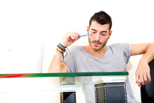 Portrait of a young man in grey shirt in the office.
