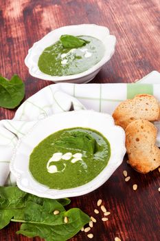 Delicious spinach soup on wooden background. Healthy soup eating. 