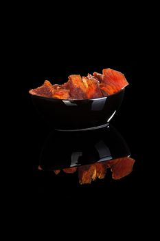 Beef jerky, dry meat isolated on black background. Culinary meat eating. 