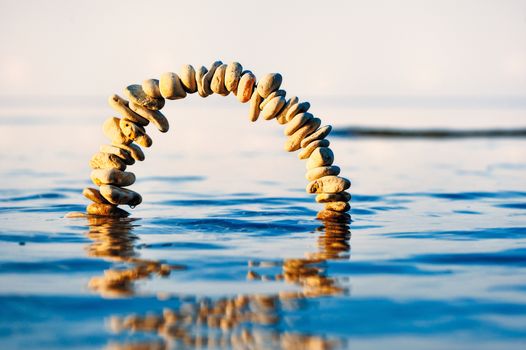 Arc of pebbles on the surface of the sea