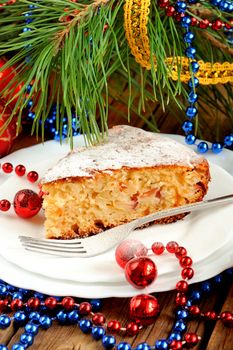 Christmas cake on white plate with fur tree and christmas toys vertical