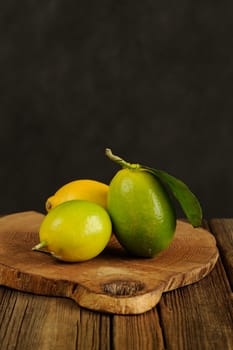 Limes and lemons on wooden board vertical