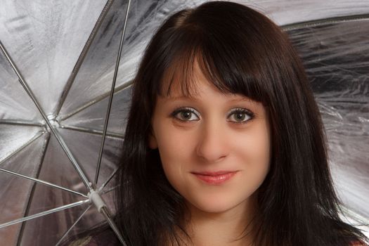 A brown haired woman under a umbrella