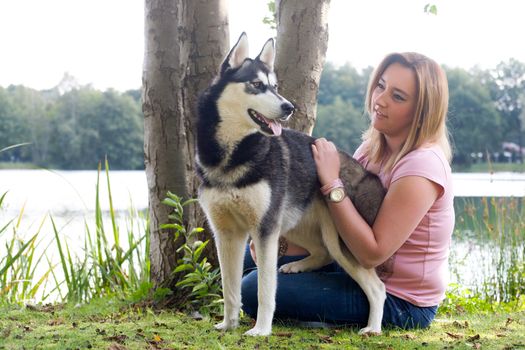 Young woman and her husky in the forest