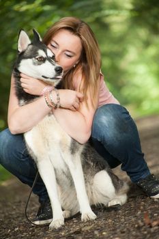 Young woman and her husky in the forest