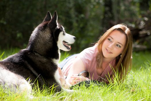 Young woman and her husky in the forest