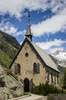 Switzerland, church among alpine mountains