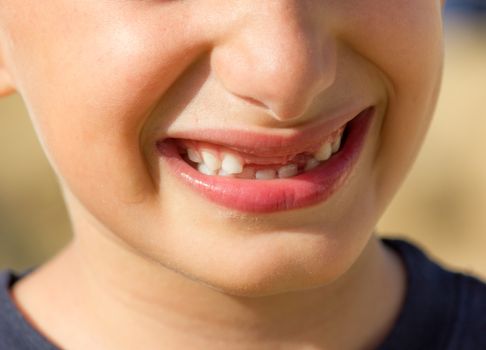 Child plays a cheerful smile without showing teeth