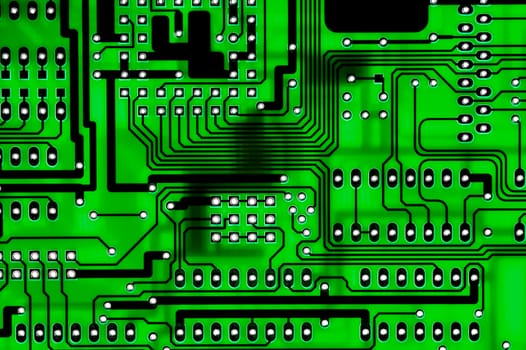 close-up a computer circuitboard showing tracks and holes