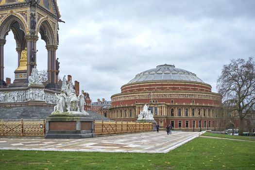 LONDON, UK - DECEMBER 17: People walking past Albert Memorial statues with Royal Albert Hall in the background, in Kensington Gardens. December 17, 2014 in London.