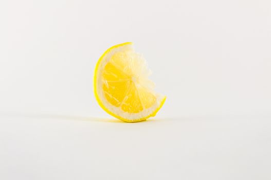 Slice of fresh lemon yellow on white background