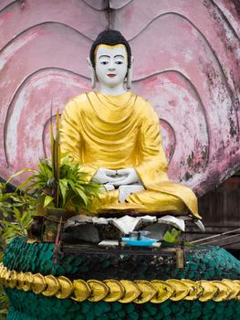 Buddha image on pink background at temple in Myeik, Myanmar