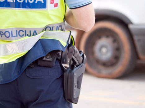 police officer in hi-visibility jacket control traffic, back view