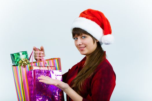 Attractive young woman in santa hat with holiday shopping