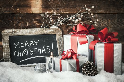 Closeup of Christmas gifts with candle and slate.