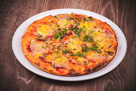 italian pizza with ham on white plate 