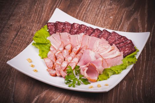 cut meat platter on white plate  on wooden background