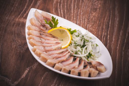 herring fish with marinated onion on white plate 